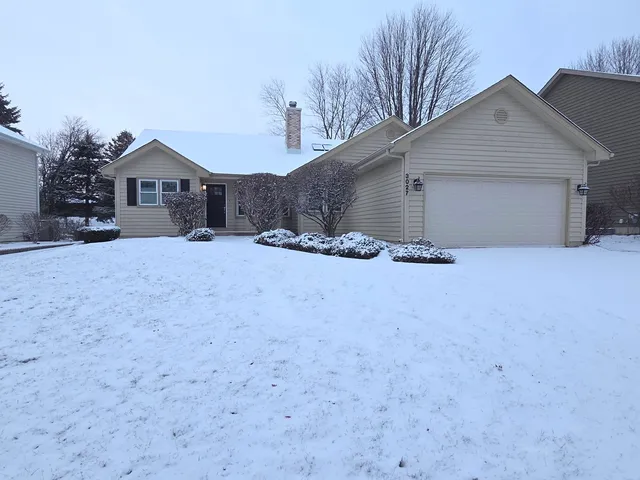 a front view of house with yard and trees in the background