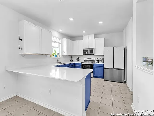 a kitchen with stainless steel appliances a refrigerator sink stove microwave and cabinets
