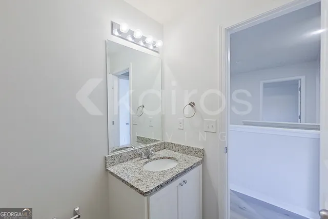 a bathroom with a granite countertop sink and a mirror