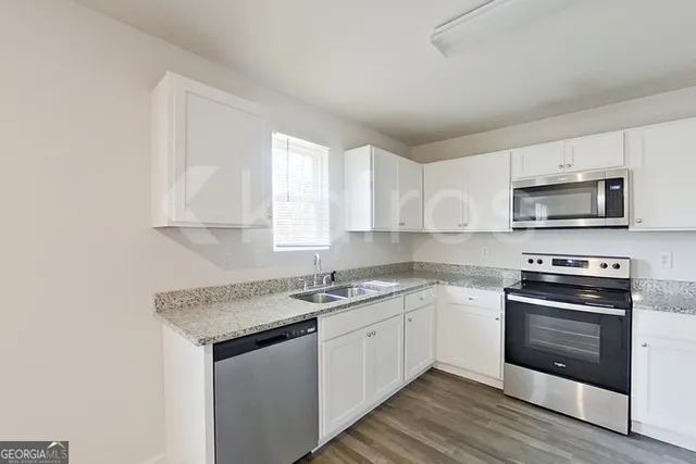 a kitchen with stainless steel appliances granite countertop a sink stove a microwave and cabinets