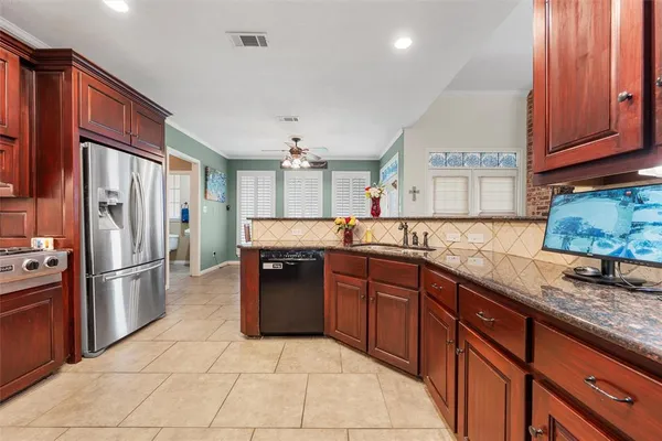 a kitchen with granite countertop a refrigerator and a sink