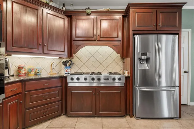 a kitchen with granite countertop stainless steel appliances and wooden cabinets