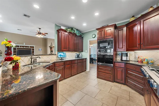 a kitchen with stainless steel appliances granite countertop a sink stove and cabinets