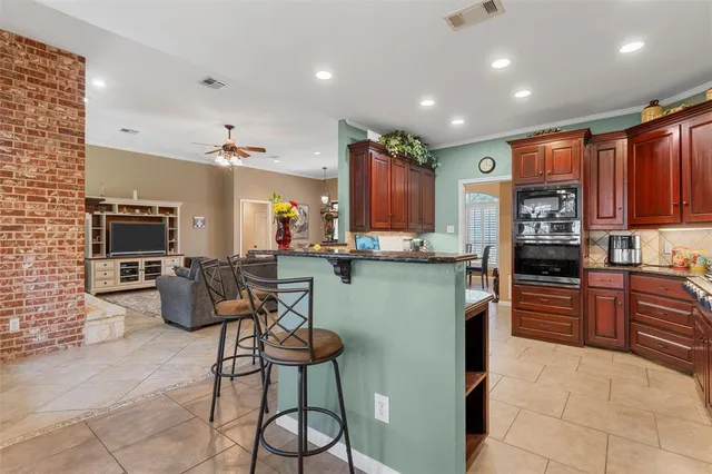 a kitchen with stainless steel appliances kitchen island granite countertop a refrigerator and microwave