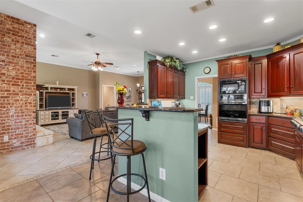 175 Winding Trail Crawford, TX 76638 - Photo 14 of 40 a kitchen with stainless steel appliances kitchen island granite countertop a refrigerator and microwave