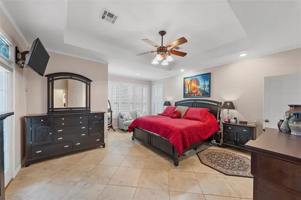 a bedroom with a large bed and a flat tv screen