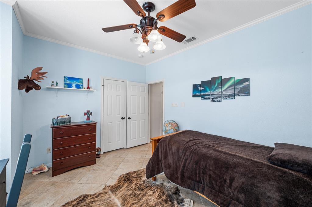 175 Winding Trail Crawford, TX 76638 - Photo 25 of 40 a bedroom with a bed and a chandelier