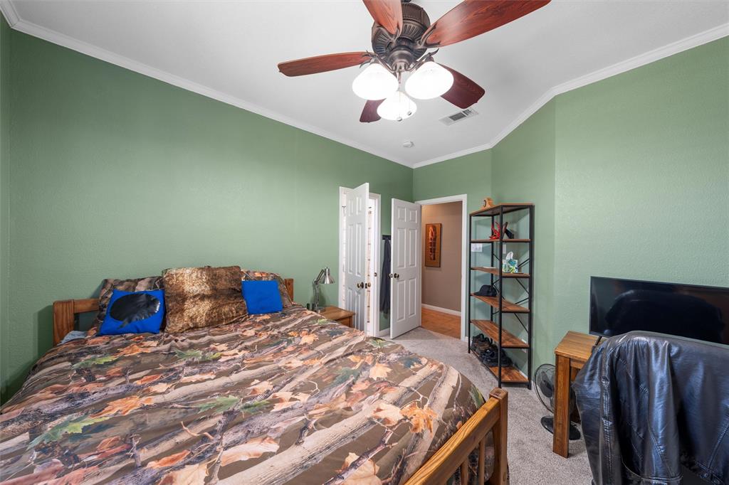 175 Winding Trail Crawford, TX 76638 - Photo 28 of 40 a bedroom with a large bed and a chandelier