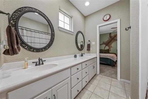 a en suite bathroom with a double vanity sink and a mirror