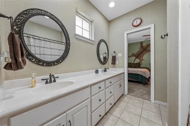 a en suite bathroom with a double vanity sink and a mirror