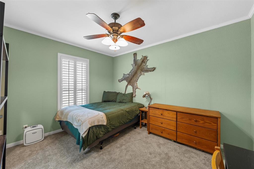 175 Winding Trail Crawford, TX 76638 - Photo 31 of 40 a bedroom with a bed and a chandelier