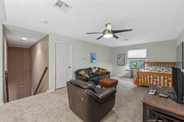 a bedroom with bed couch and window