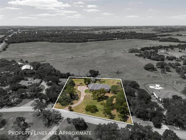 an aerial view of a house with a lake