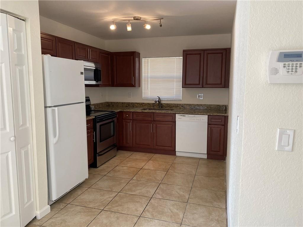 1120 West 9th Street Riviera Beach, FL 33404 - Photo 5 of 10 a kitchen with stainless steel appliances granite countertop a refrigerator a sink a stove top oven and a dishwasher