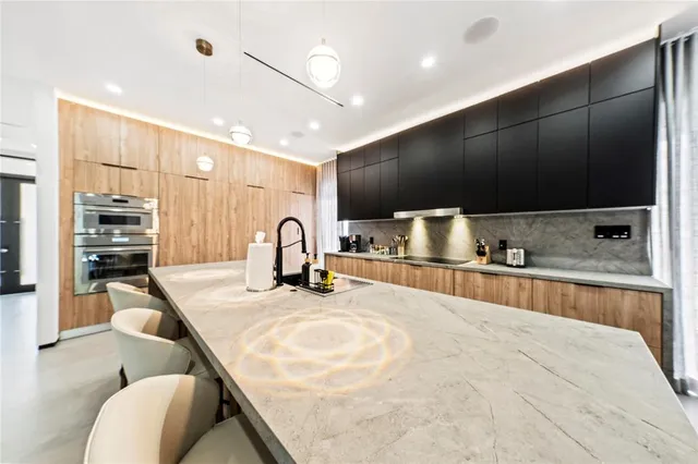 a kitchen with stainless steel appliances kitchen island granite countertop a sink and a stove top oven