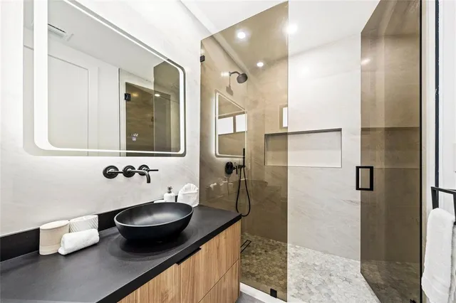 a bathroom with a granite countertop sink and a mirror