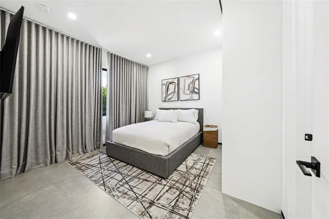 a bedroom with a large bed and a night stand