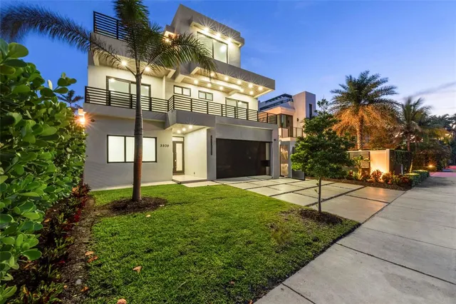 a view of a house with a yard and potted plants