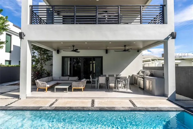 a view of a patio with table and chairs potted plants and large tree