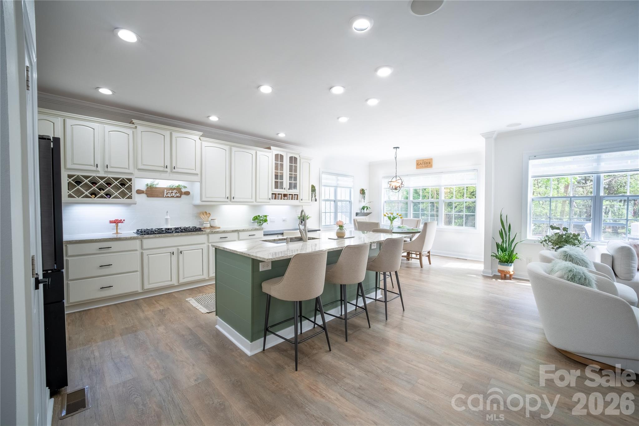12058 Pelican Court Tega Cay, SC 29708 - Photo 34 of 43 a kitchen with a dining table chairs and white cabinets