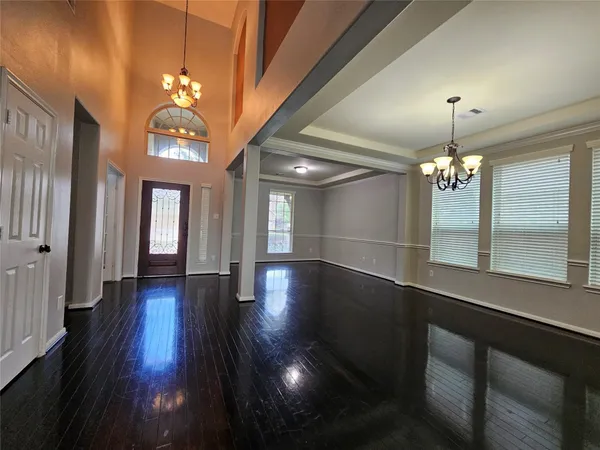 a view of entryway and kitchen with stainless steel appliances wooden floor and chair
