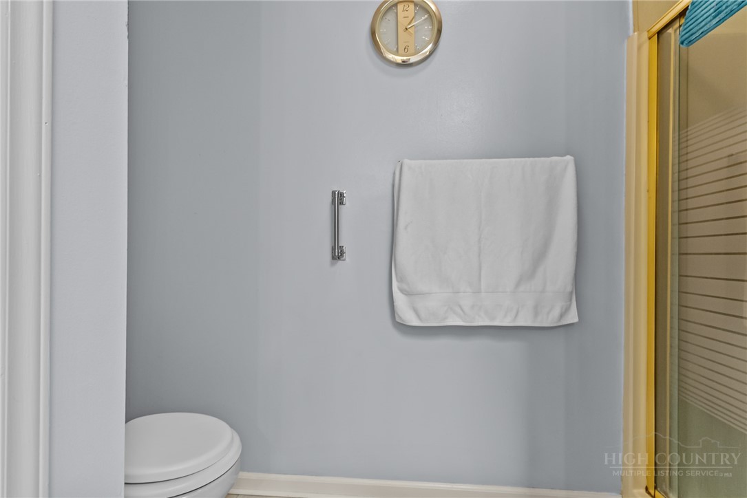 271 Quail Hollow Road Crumpler, NC 28617 - Photo 25 of 30 a white toilet sitting next to a shower curtain