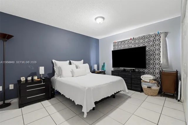 a bedroom with bed and a flat screen tv