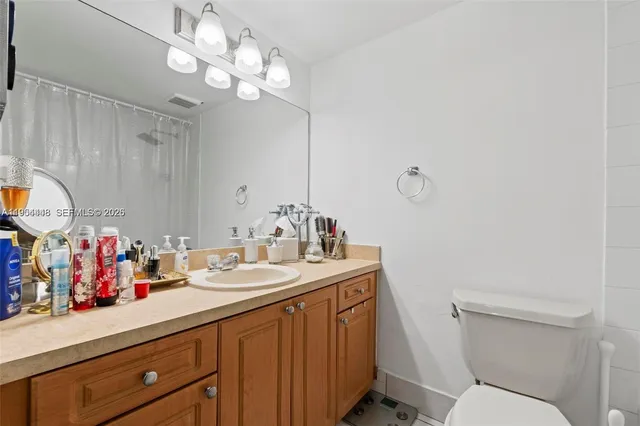 a bathroom with a sink vanity mirror and toilet
