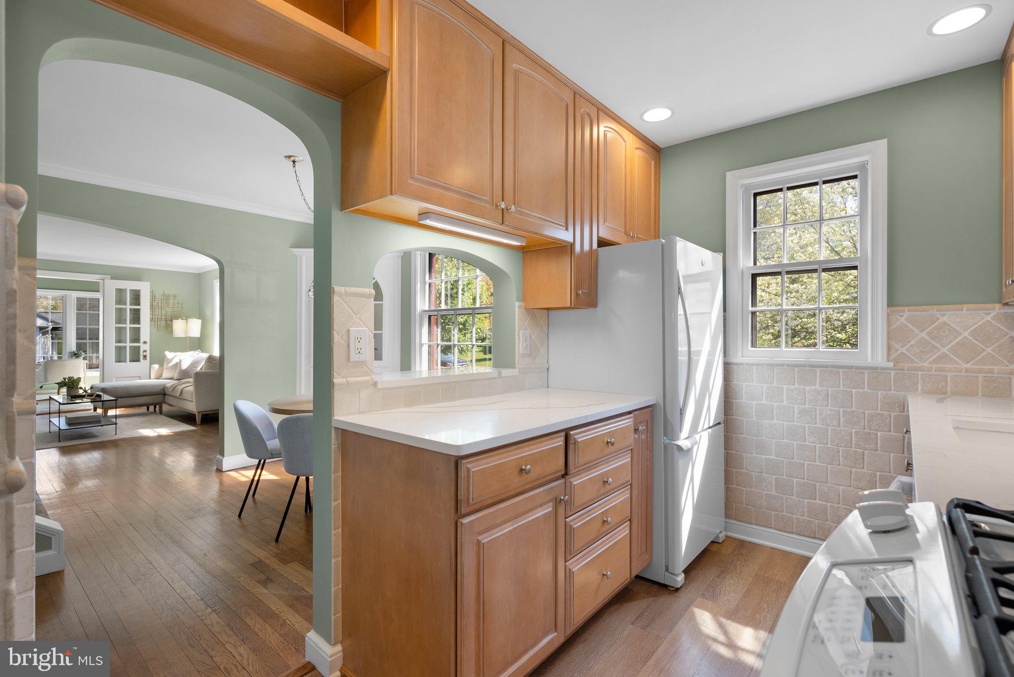 10210 Pierce Drive Silver Spring, MD 20901 - Photo 13 of 49 a kitchen with stainless steel appliances granite countertop a refrigerator a sink dishwasher a stove and white countertops with wooden floor