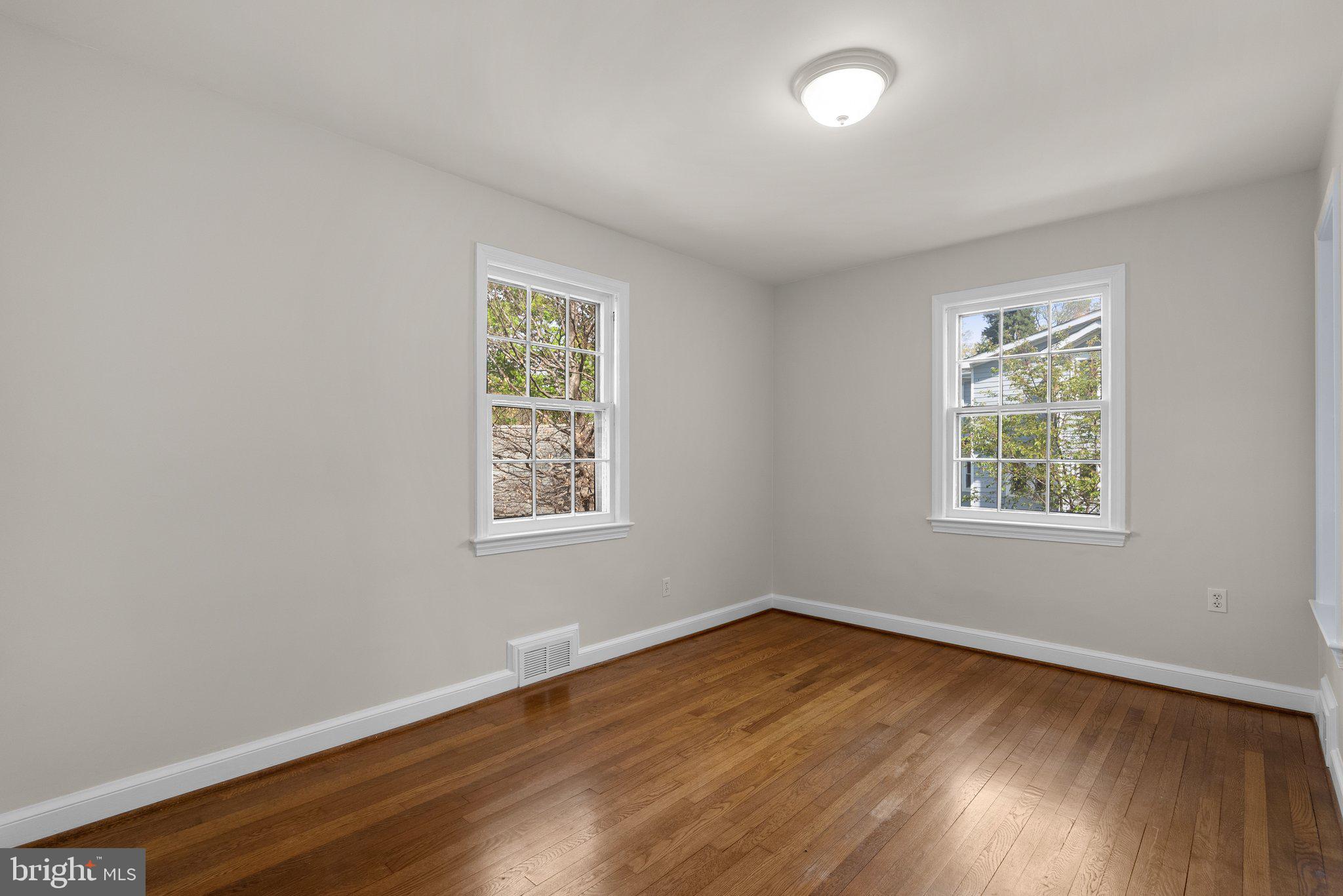 10210 Pierce Drive Silver Spring, MD 20901 - Photo 16 of 49 an empty room with wooden floor and windows