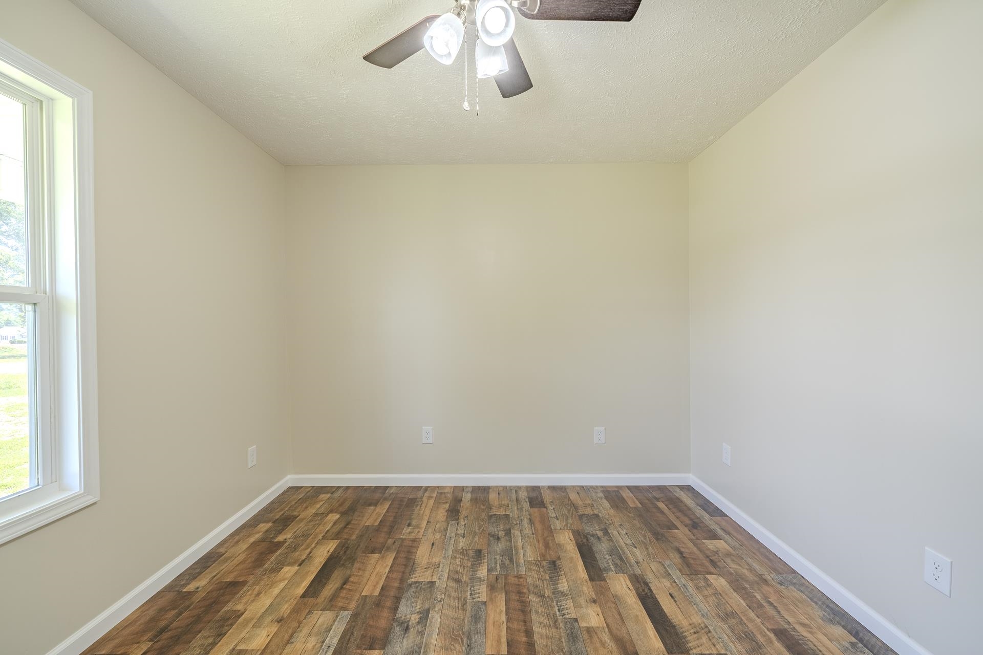 231 Clausel Lane Adamsville, TN 38310 - Photo 16 of 32 a view of an empty room with wooden floor and a window