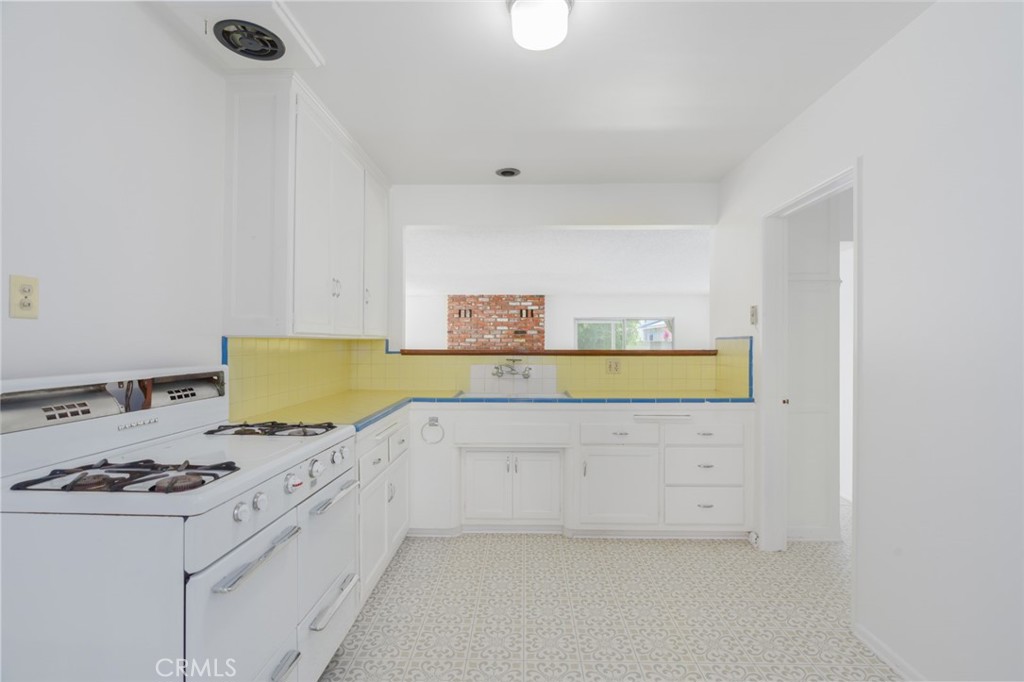 13792 Figueroa Street Garden Grove, CA 92843 - Photo 8 of 38 a kitchen with a stove a white cabinet and a refrigerator