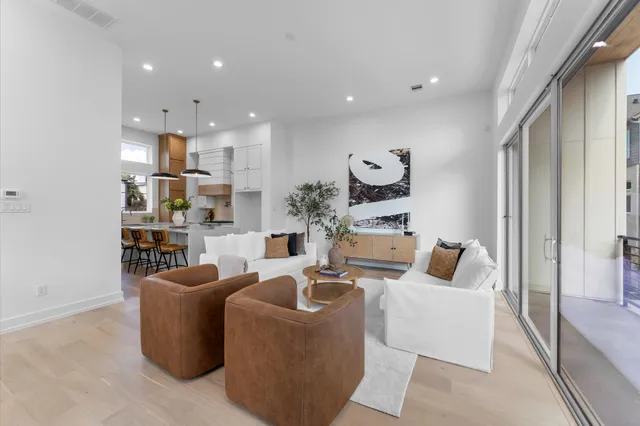 a living room with furniture kitchen view and a large window