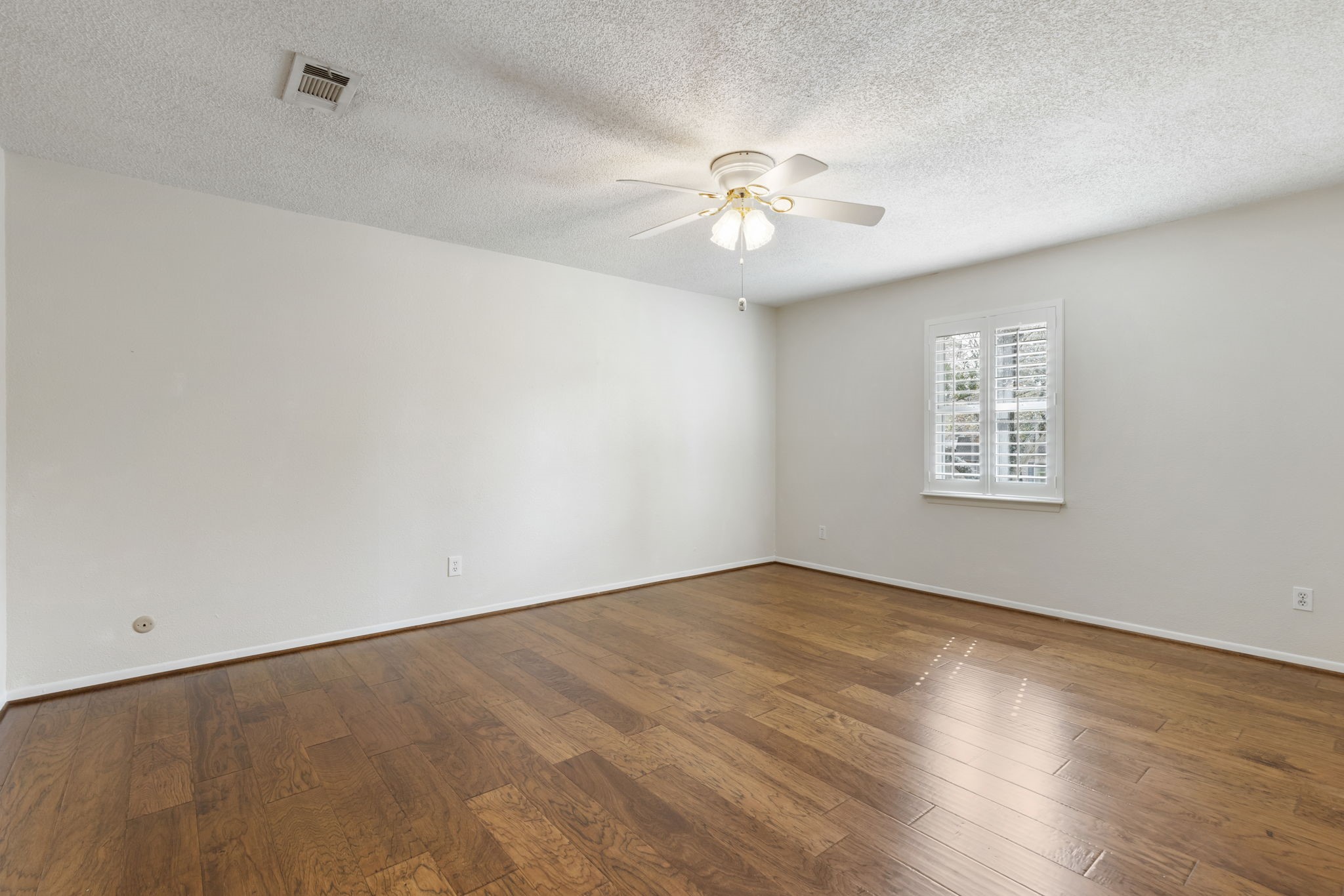6414 Hickorycrest Drive Spring, TX 77389 - Photo 26 of 49 an empty room with wooden floor fan and windows