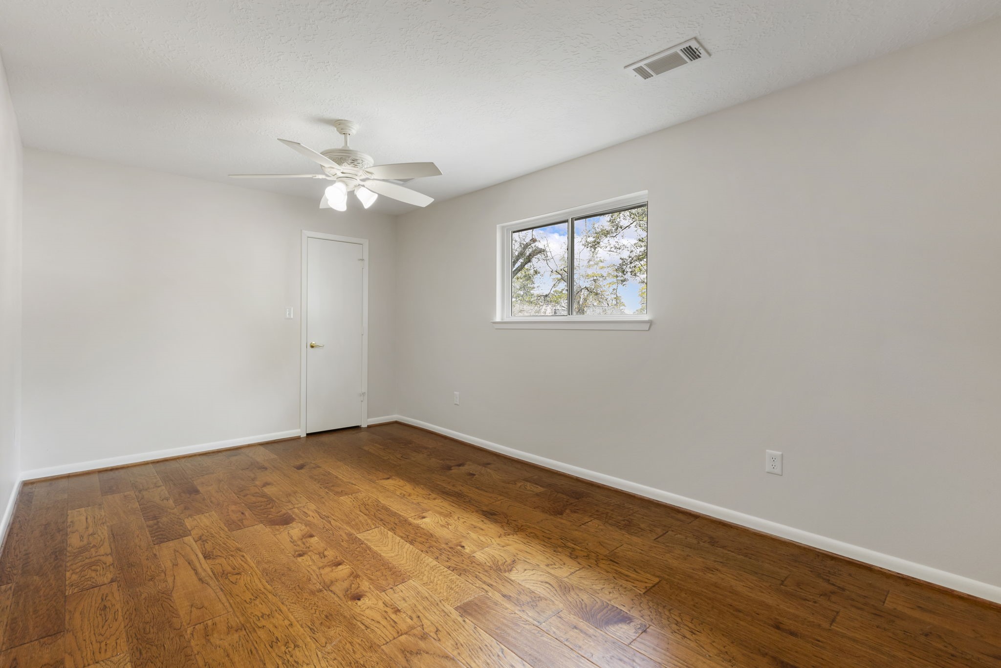 6414 Hickorycrest Drive Spring, TX 77389 - Photo 30 of 49 an empty room with wooden floor chandelier fan and windows