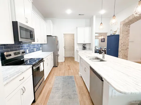 a large kitchen with stainless steel appliances kitchen island granite countertop a sink and cabinets