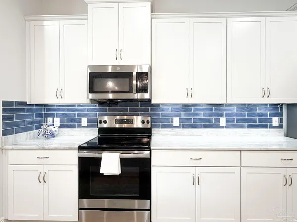 a kitchen with granite countertop a sink a stove and cabinets