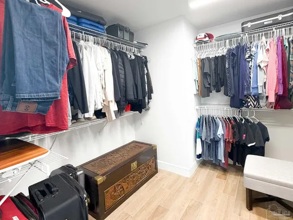 a view of walk in closet with clothes and shoes