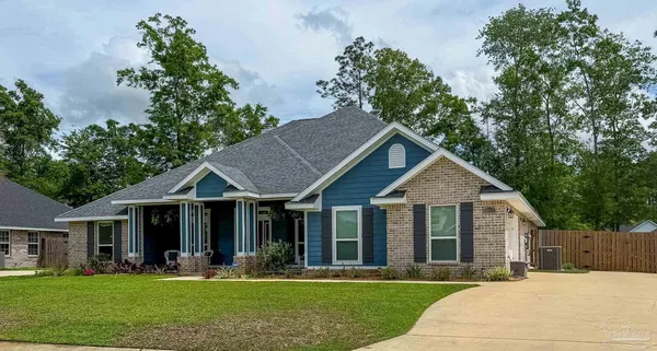 a front view of a house with a yard garden and trees