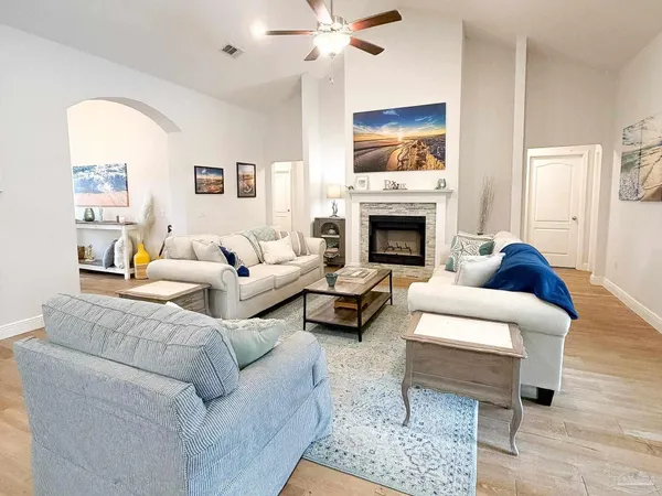 a living room with furniture a fireplace and a large window