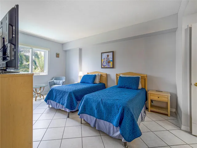 a bedroom with two beds and a window