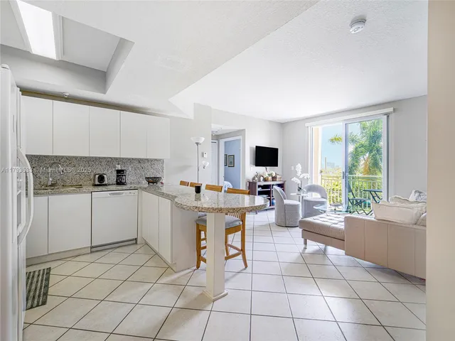 a kitchen with a stove a sink and white cabinets