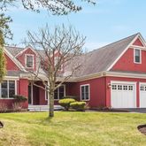 a view of a house with a big yard and large tree