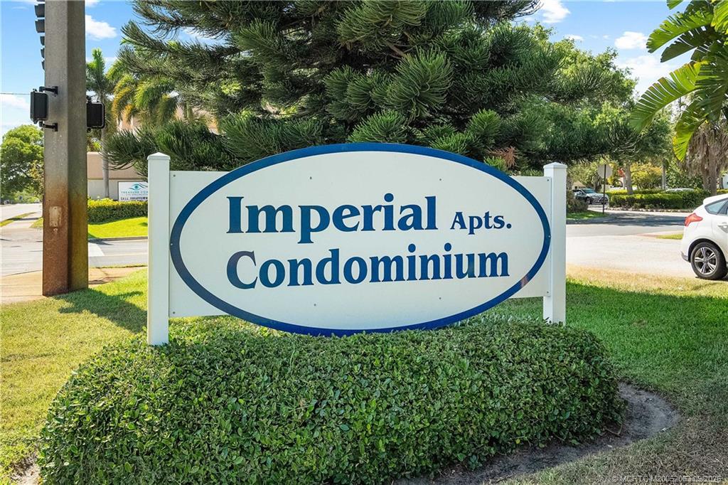 a sign of golf club on a wall under a tree