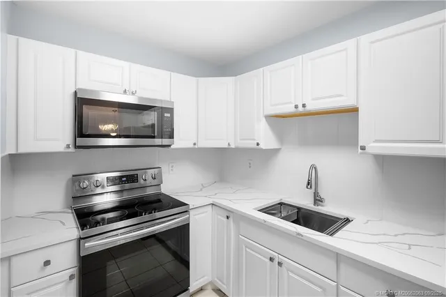 a kitchen with white cabinets and stainless steel appliances
