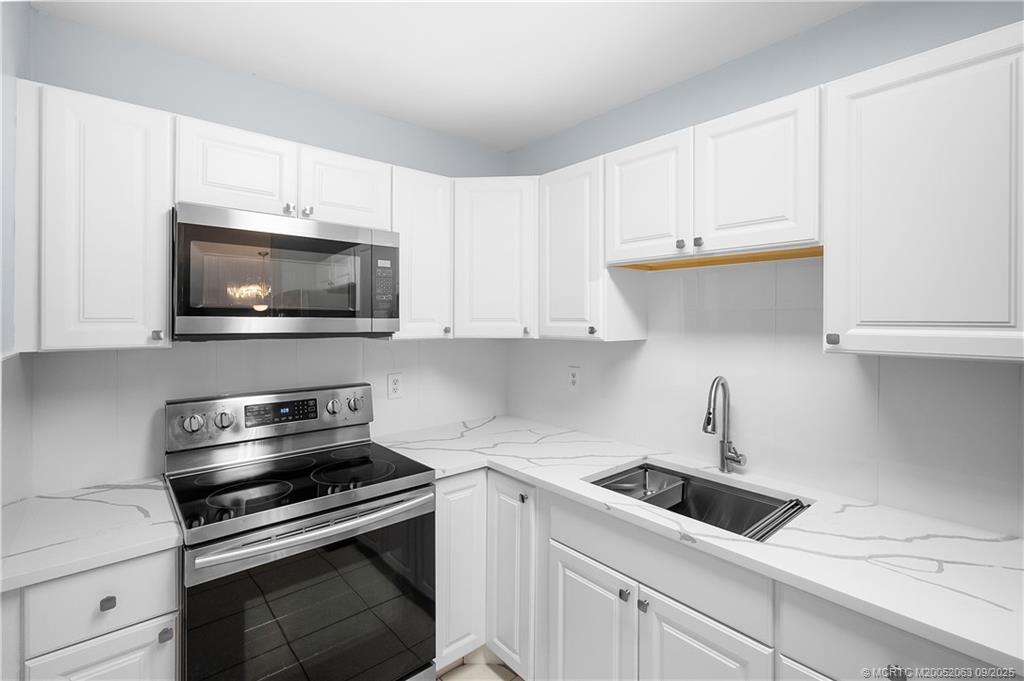 333 Southeast Martin Avenue, Unit 1A Stuart, FL 34996 - Photo 11 of 23 a kitchen with white cabinets and stainless steel appliances