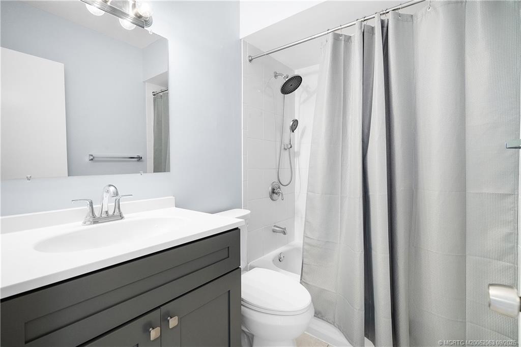 333 Southeast Martin Avenue, Unit 1A Stuart, FL 34996 - Photo 14 of 23 a bathroom with a sink a toilet a shower and a mirror