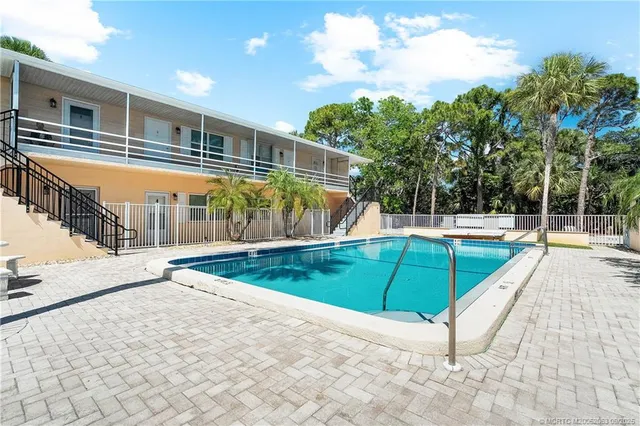 a view of a tennis ground with large trees