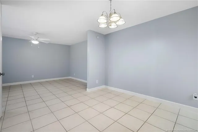 an empty room with a chandelier fan