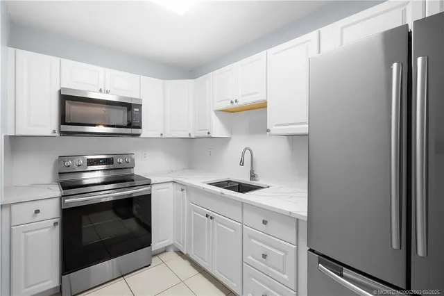 a kitchen with white cabinets stainless steel appliances and sink